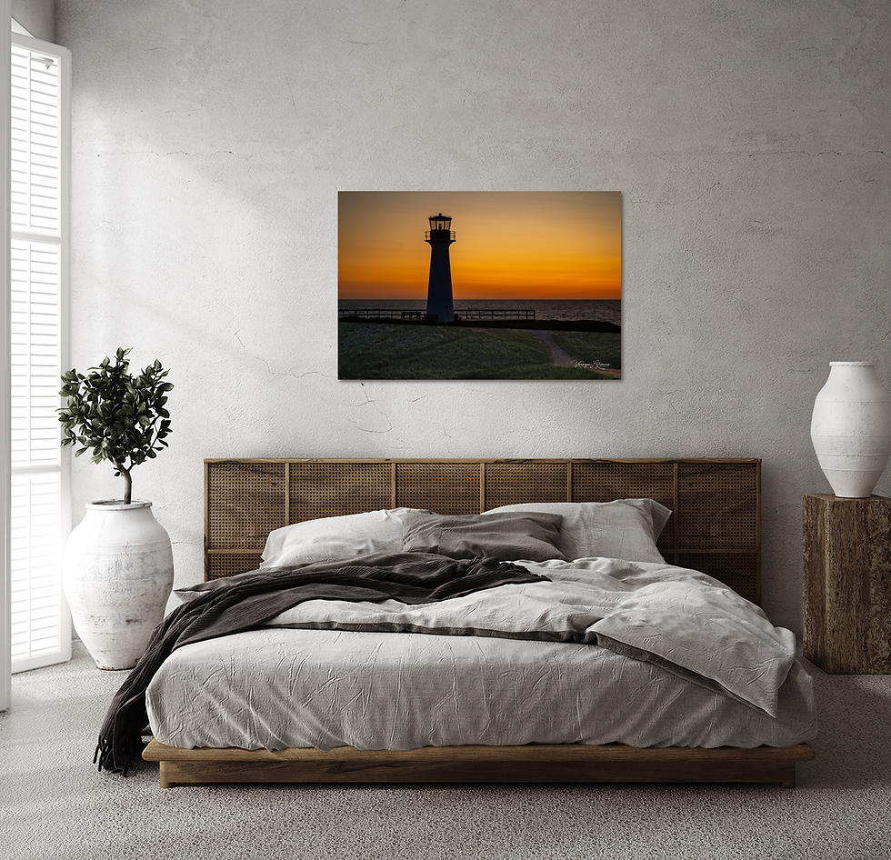 Miniature : Chambre moderne avec grand lit et tableau d'un phare au coucher du soleil.