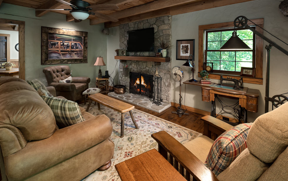 Cozy living room with fireplace, window, and comfortable seating arrangements.