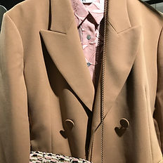 beige coat and pink shirt with printed bag