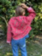 Veste rouge fleuri portée par une femme vue de dos