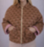 Veste matelassée à motifs marrons avec intérieur vichy rouge portée par une femme vue de face