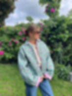 Veste matelassée verte à motifs fleuris avec intérieur rose portée par une femme