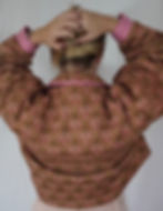 Veste matelassée à motifs marrons avec intérieur vichy rouge portée par une femme vue de dos