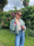 Veste matelassée verte à motifs fleuris avec intérieur rose portée par une femme