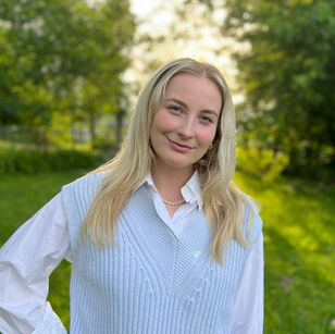Woman in light blue vest and white shirt