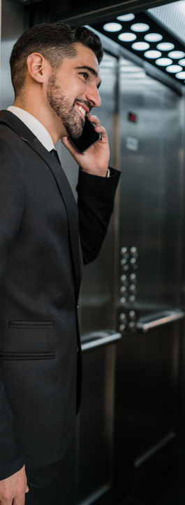portrait-young-businessman-talking-phone-hotel-elevator-business-travel-concept.jpg