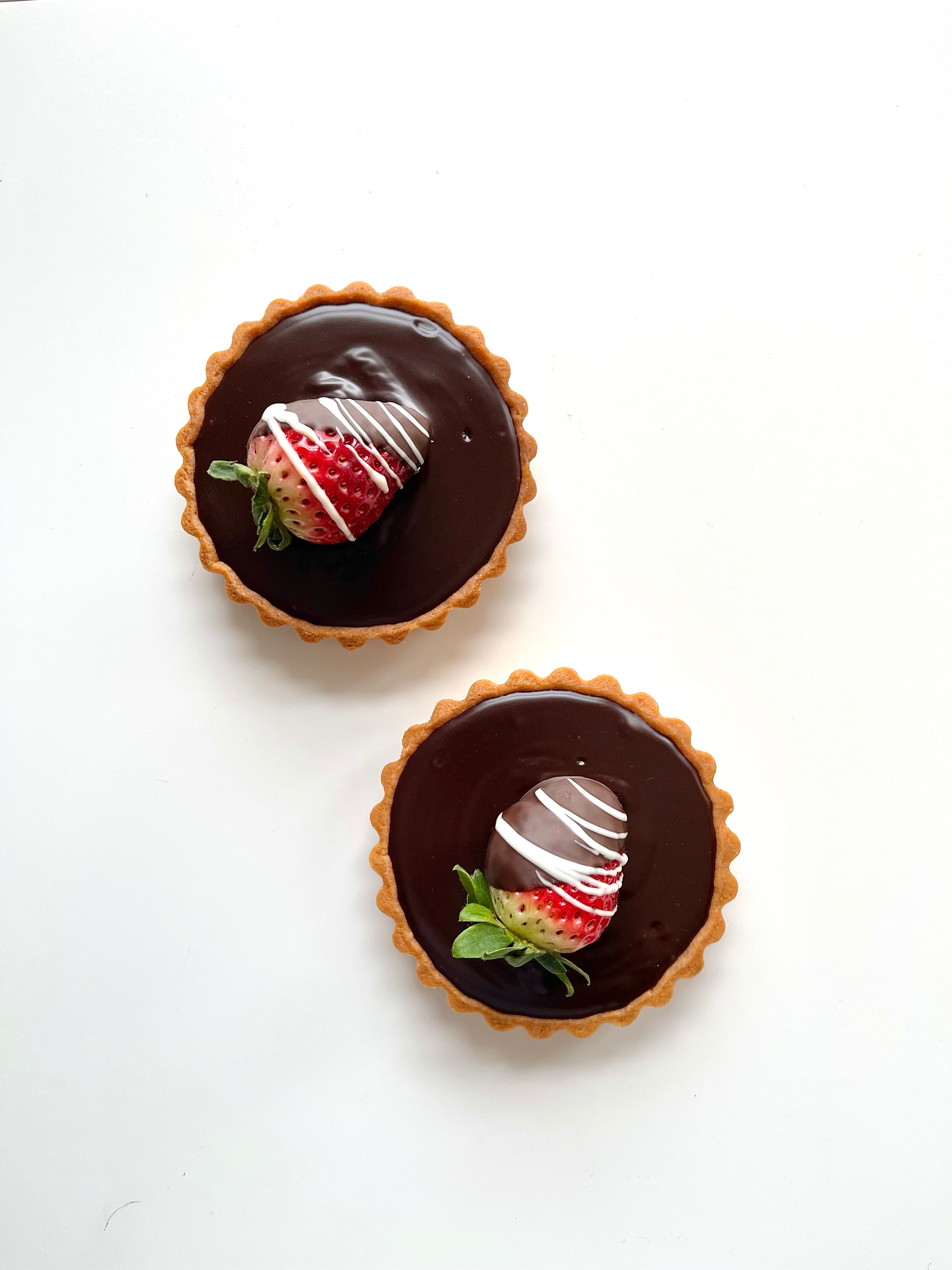 Chocolate ganache tart topped with a chocolate dipped strawberry