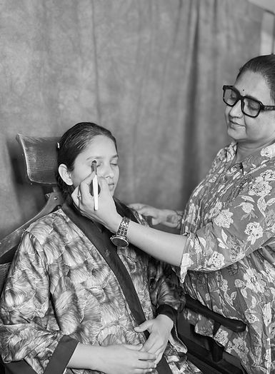 Kavita dubey A makeup artist applying eye makeup to a seated woman during a beauty session inside a salon.