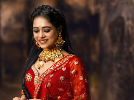 Professional makeup artist bridal look in red saree with gold jewelry and flawless makeup