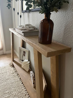 Lightly stained entry table with angled support legs.