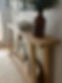 Lightly stained entry table with angled support legs.