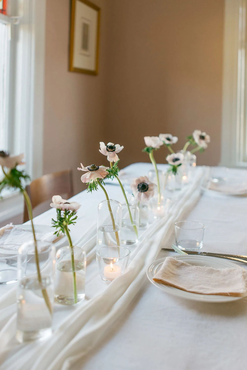 anemone flowers in glass bottles wedding table centrepiece