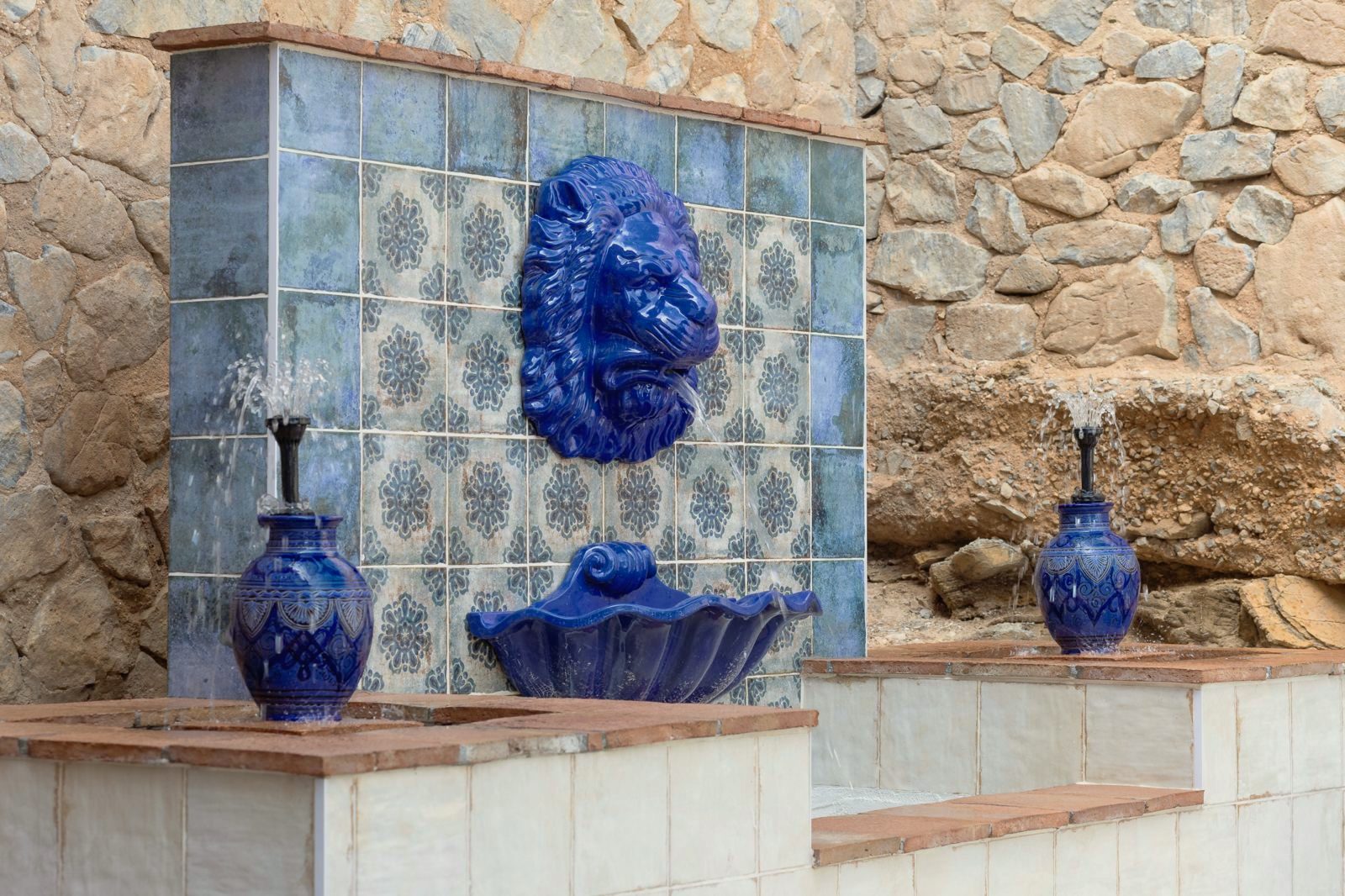 Andalusian tiled fountain with a blue lion head