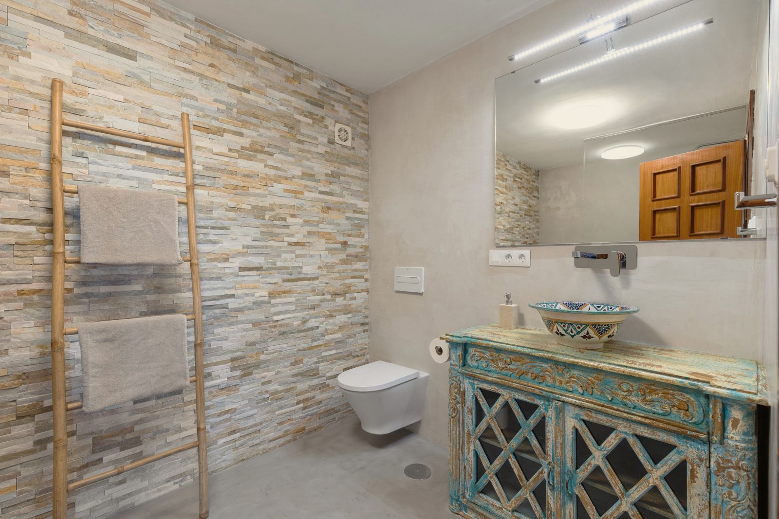 Musa Suite: bathroom with stone wall and painted vanity