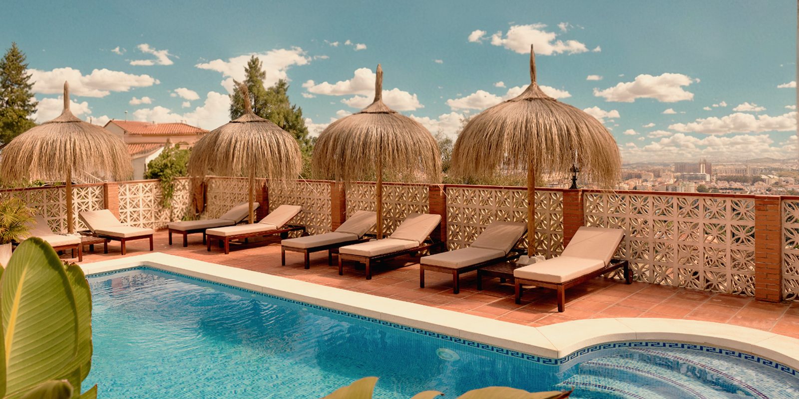 Pool with straw parasols and views over Málaga