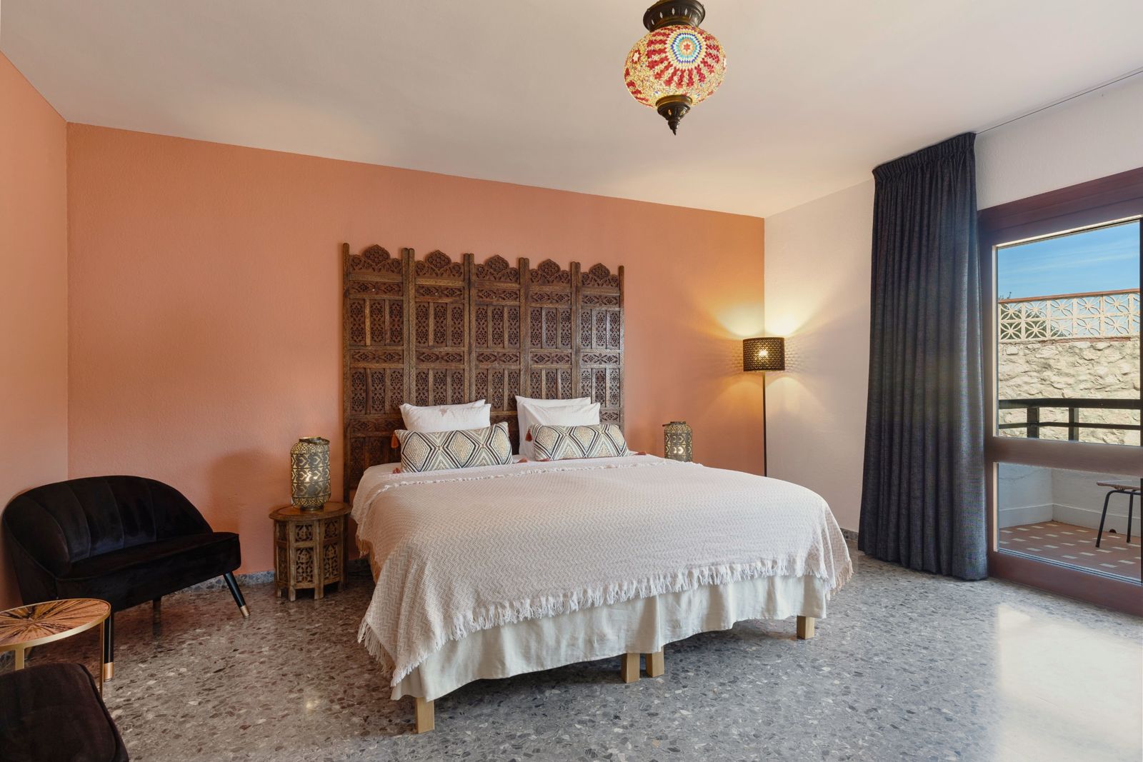Nicolai Suite: terracotta bedroom with carved headboard