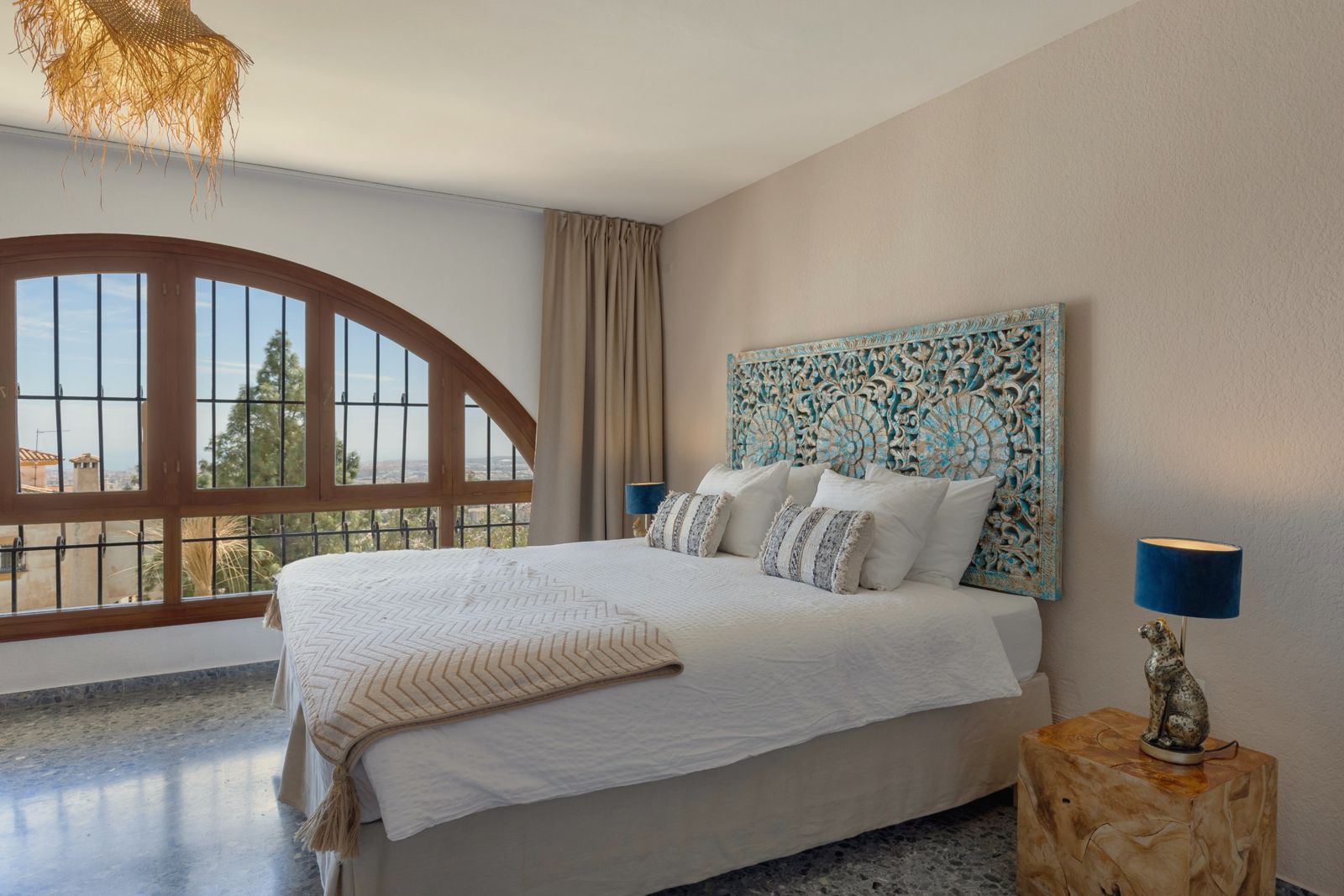 Musa Suite bedroom with arched window and view