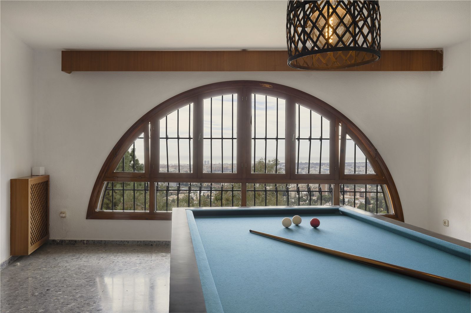 Billiard room with a large arched window
