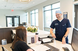 Surgeon leaning on reception desk
