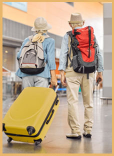 senior couple traveling at the airport with luggage