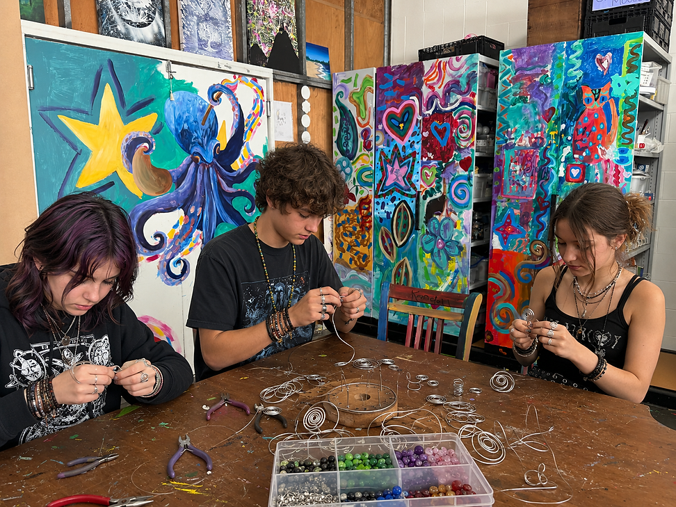 Three alternative teenages creating wire rings at creativity hood art school, townsville,