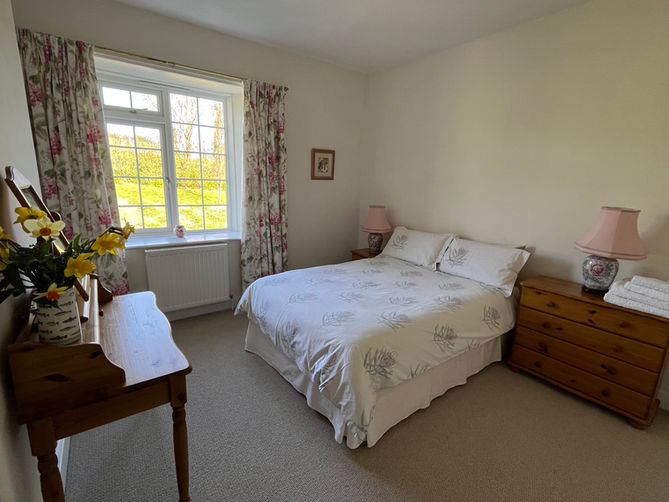double bedroom with en suite shower and toilet, traditional farmhouse style with dressing table and lamps Down House Farm Devon EX6 7SA