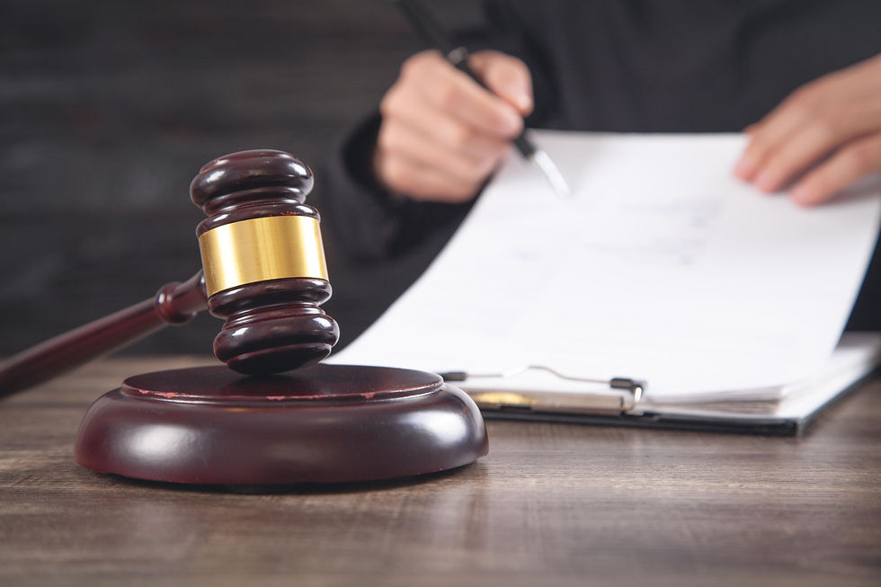 A judge sits behind a grovel reviewing the documents of a case.