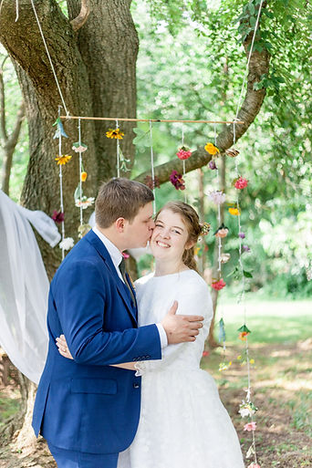 Bride and groom outdoors groom kissing bride's cheek