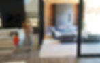 Mother with children walking through automated sliding glass door in modern home with UL 325 safety compliance and entrapment protection