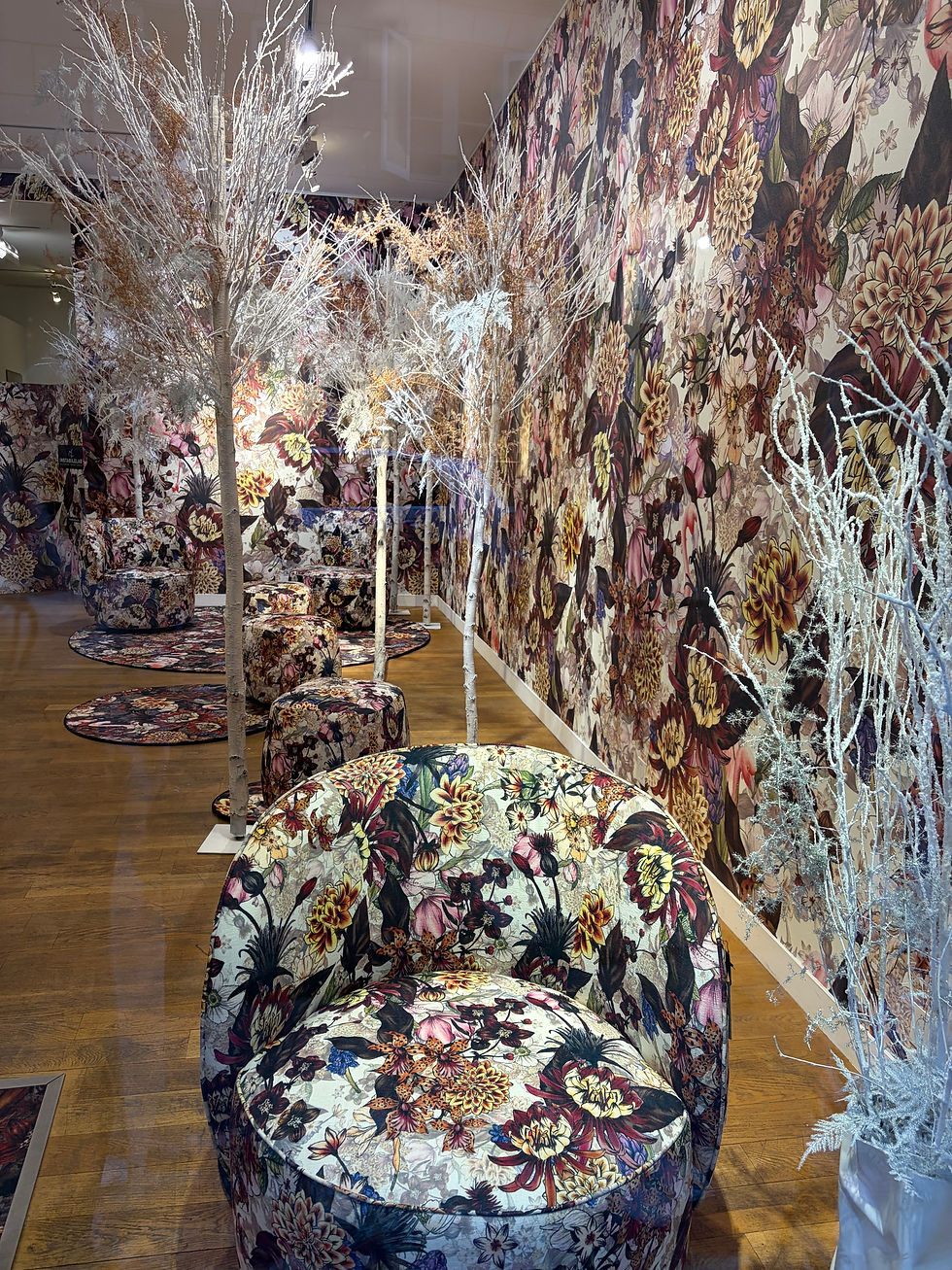 Maximalist floral upholstered chairs with botanical wallpaper demonstrating layered pattern interior design trends