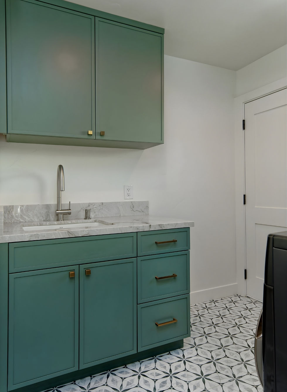 Laundry room with forest green cabinetry, brushed gold hardware, Le Blanc quartzite countertop, and geometric cement tile floor in Willow Glen whole-home remodel