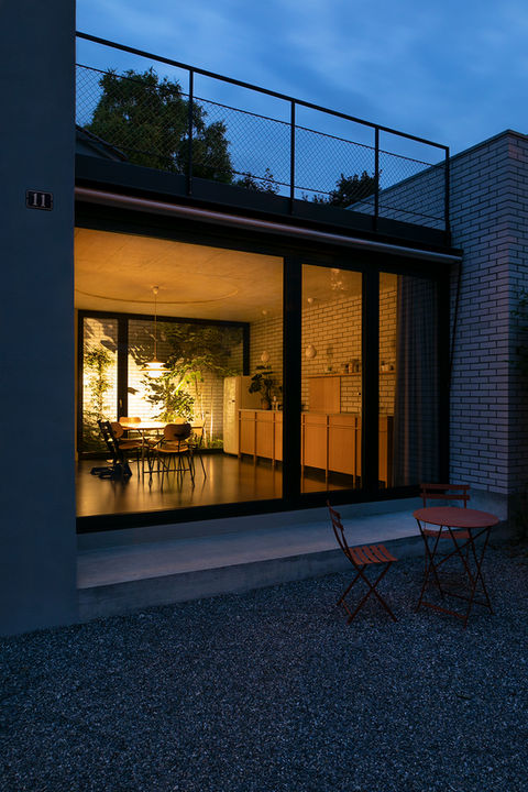 Aussenansicht des beleuchteten Anbaus mit Wohnküche in der Nacht eines renovierten Haus mit neuem Anbau in Biel.