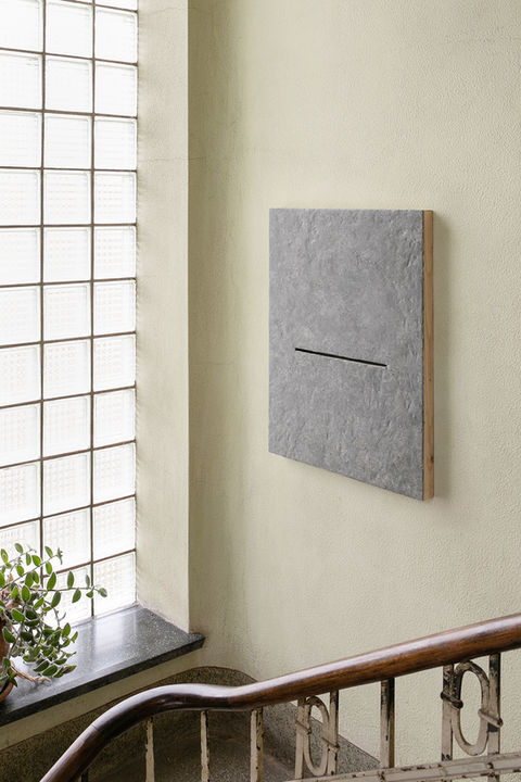 Graues Bild mit Schlitz von Künstler Jérôme Stünzi ausgestellt im Gang seines Ateliers in Biel.