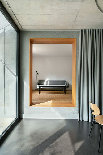 Blick von Wohnküche durch Durchgang in das Wohnzimmer in einem renovierten Haus mit neuem Anbau in Biel.