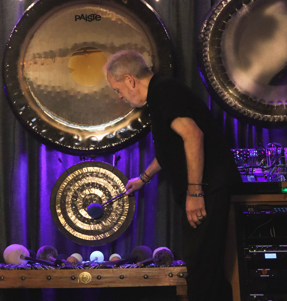 Man playing gong in sound healing studio near Brighton