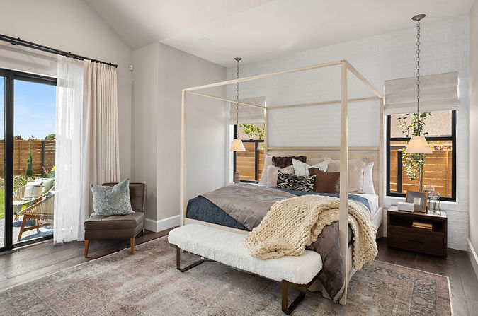 Staged bedroom in the “Bespoke” Street of Dreams home, featuring cozy layered bedding and timeless interior design by Greylyn