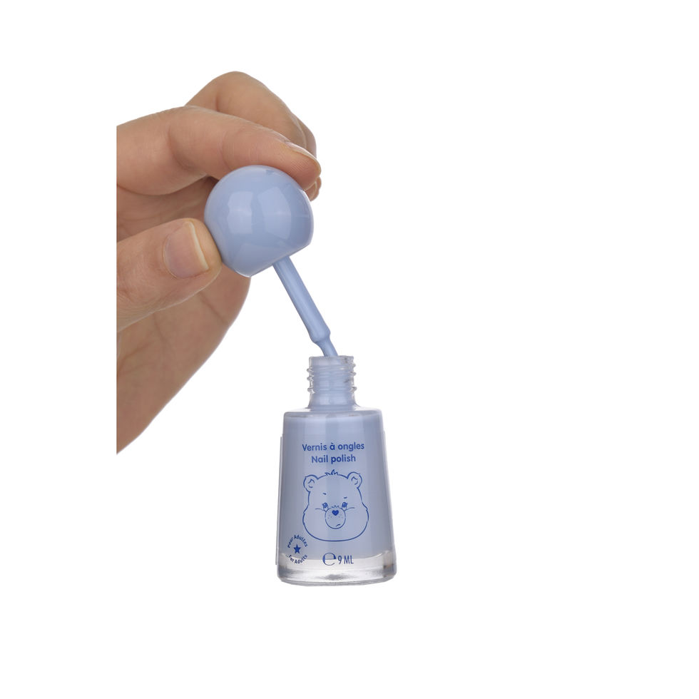 Hand holding the brush of Care Bears 9ml blue nail polish
