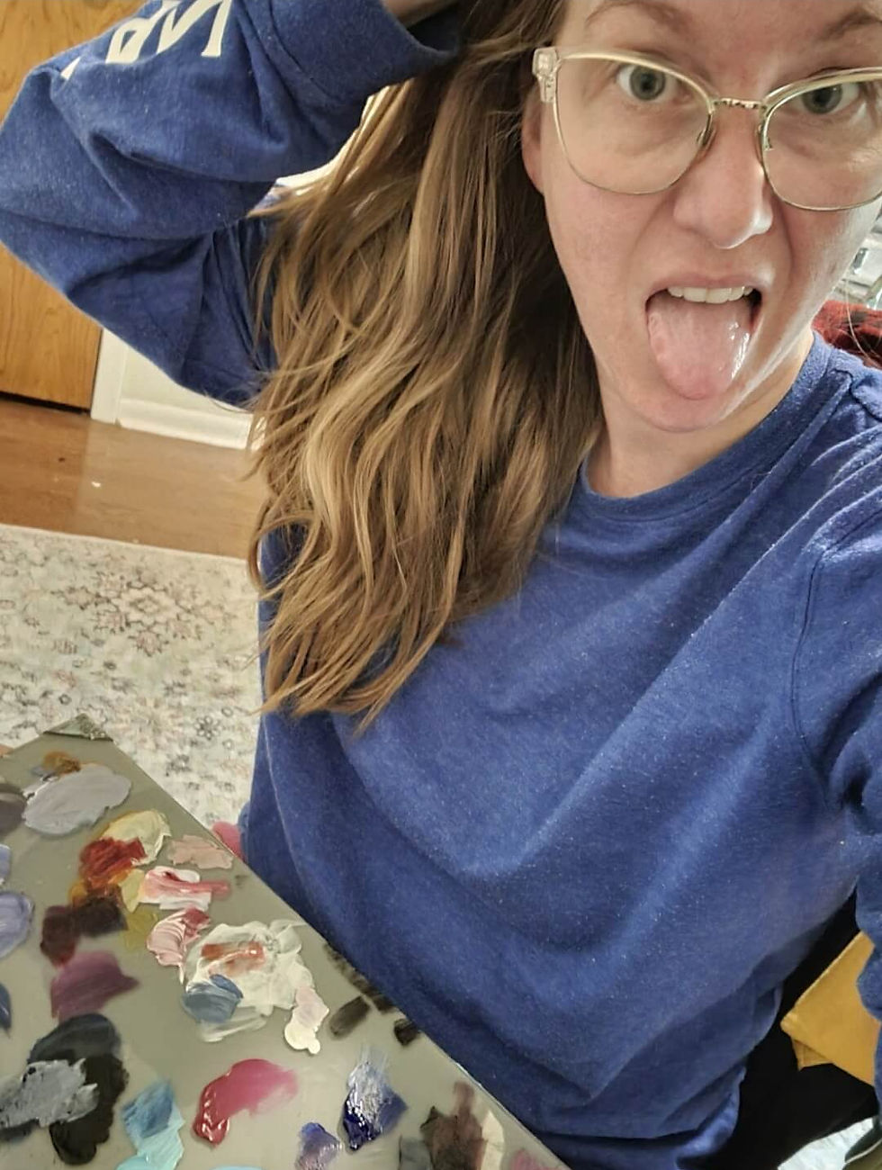 Mandi Murphy taking a selfie with her tongue sticking out and a paint pallet