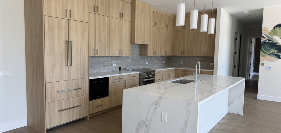 Floor-to-ceiling light oak custom kitchen cabinets with marble waterfall island in Danville, CA