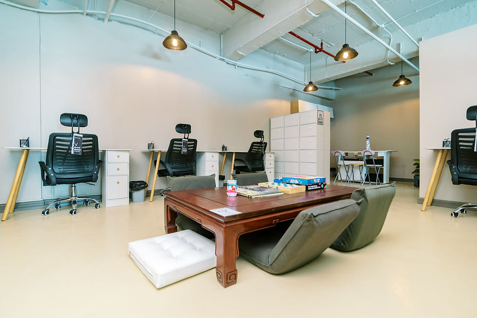 Eye-level view of a bright coworking desk with a laptop and coffee cup