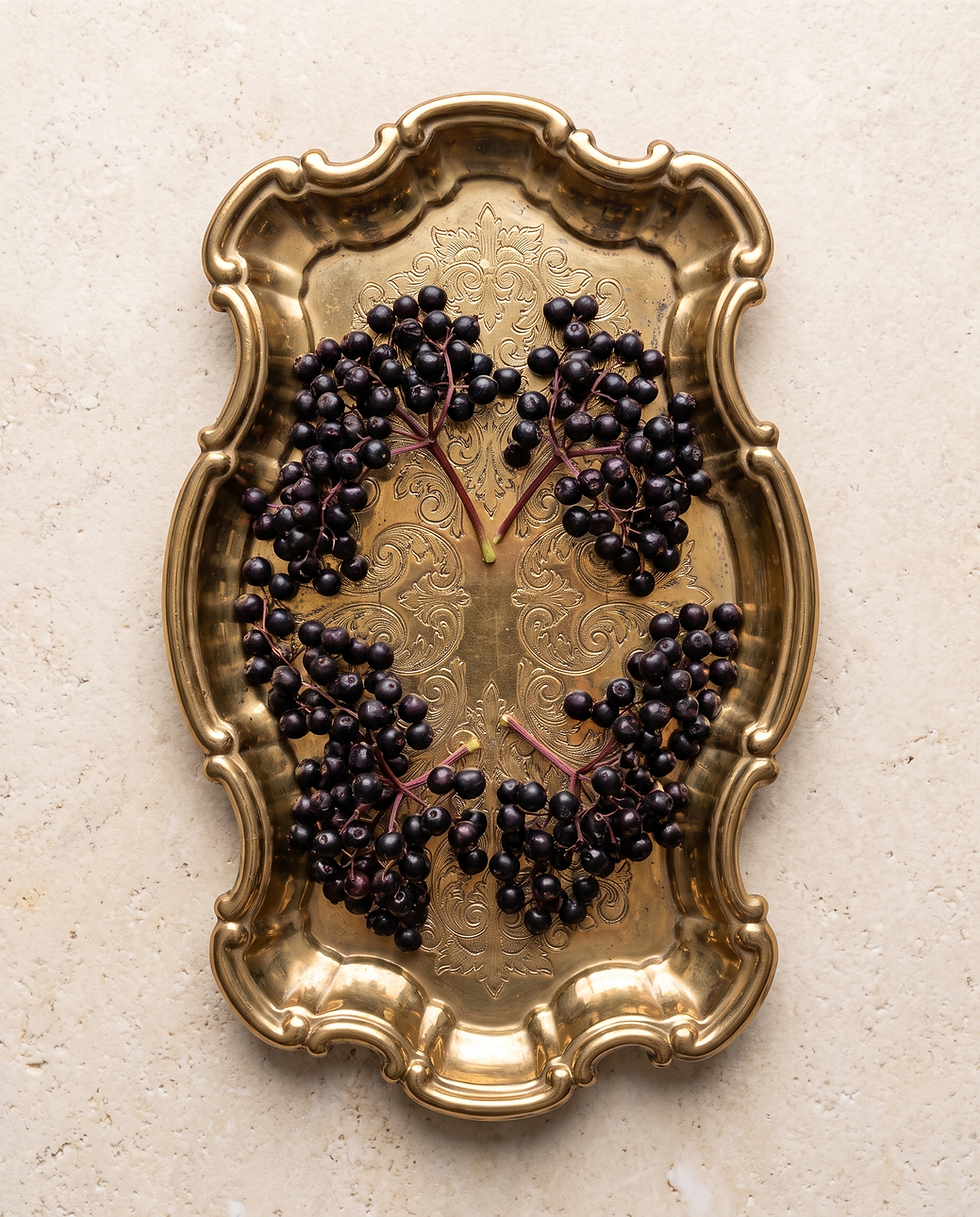 Elderberries arranged inside an ornate antique brass frame