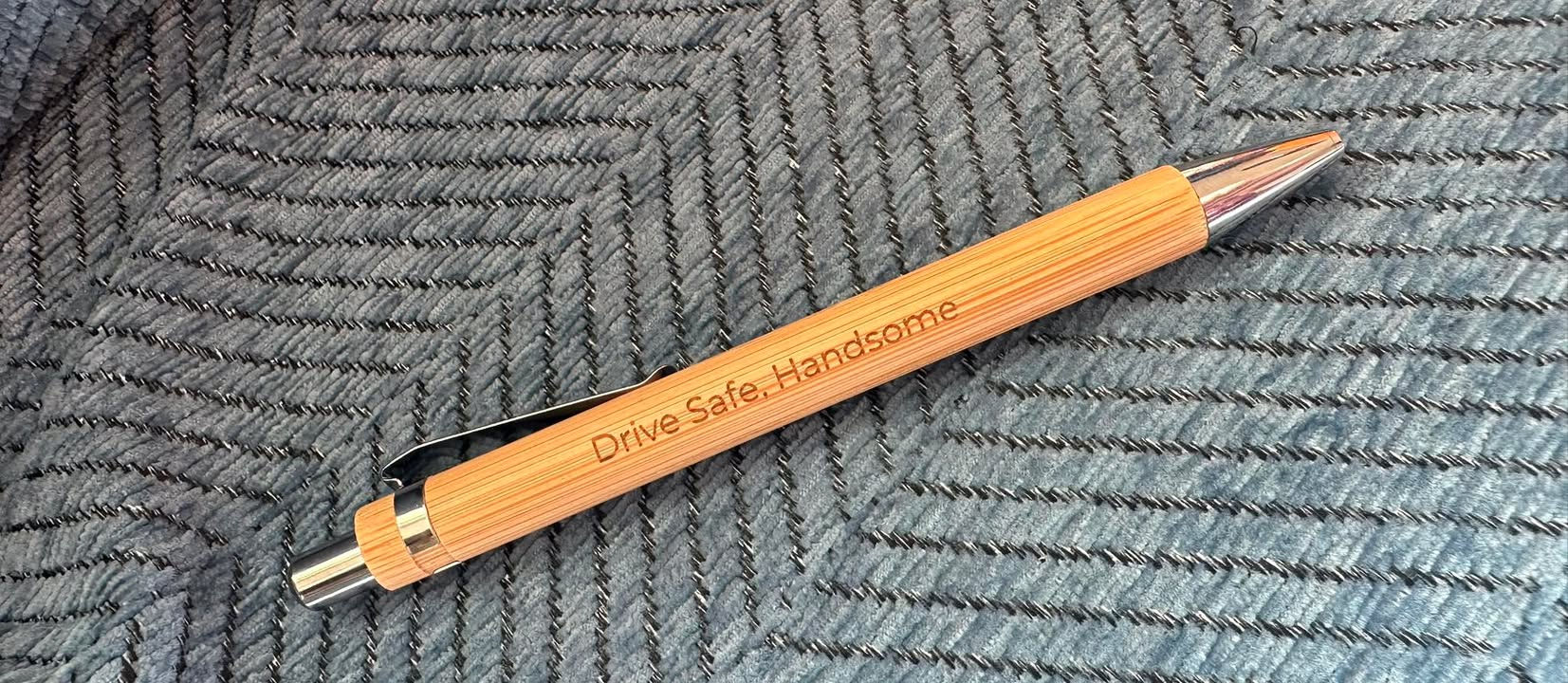 A collection of personalised bamboo pens featuring custom laser engravings.