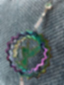 Rainbow hummingbird garden wind spinner with wavy edges.