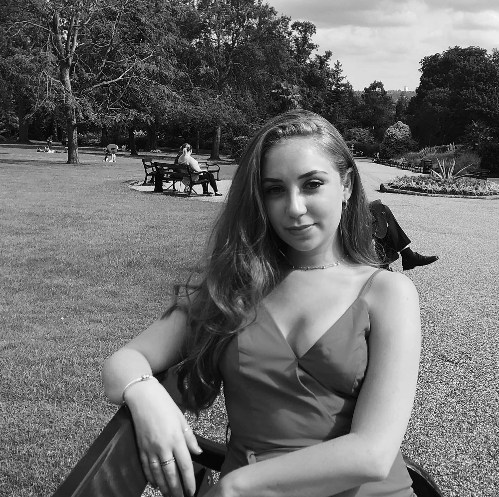 LGBT+ ambassador Charlotte, sitting in a field
