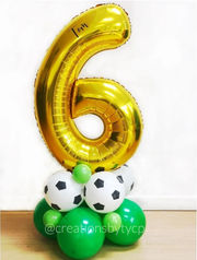 Balloon bouquet with metallic gold extra large number 6 on top of two balloon layers in a green and white soccer theme