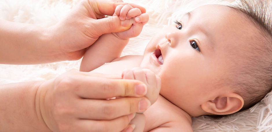 手をマッサージされている赤ちゃん