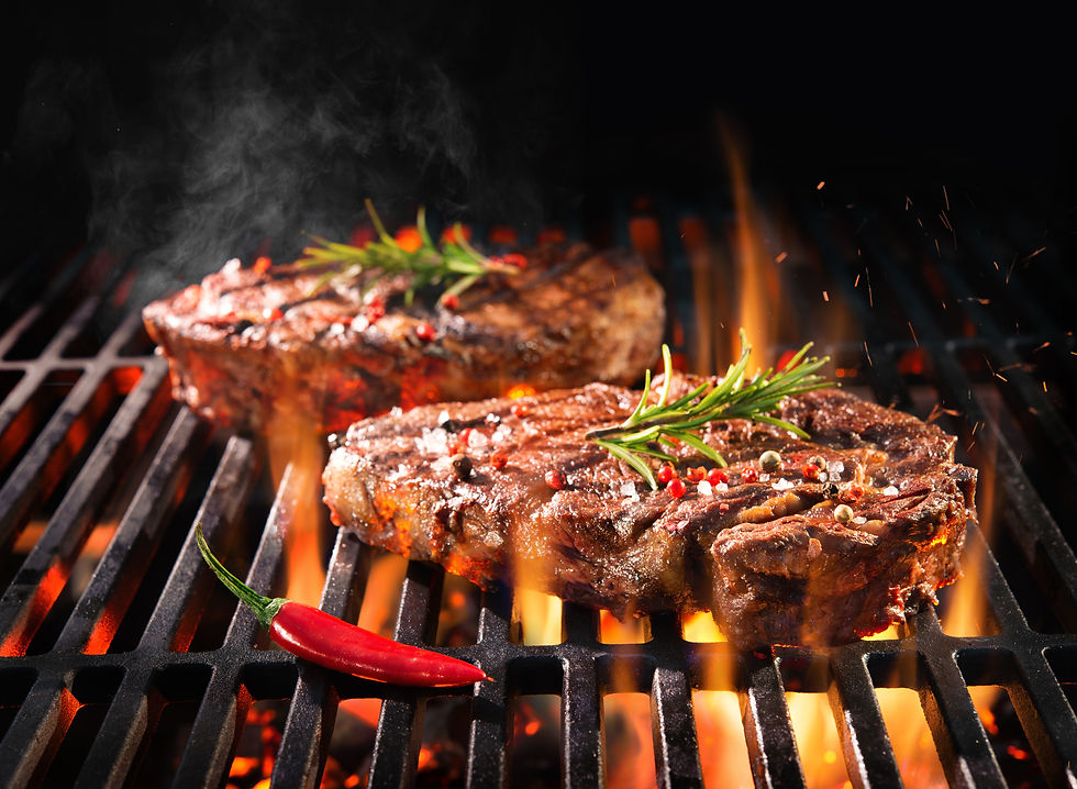 Beef steaks sizzling on the grill with flames