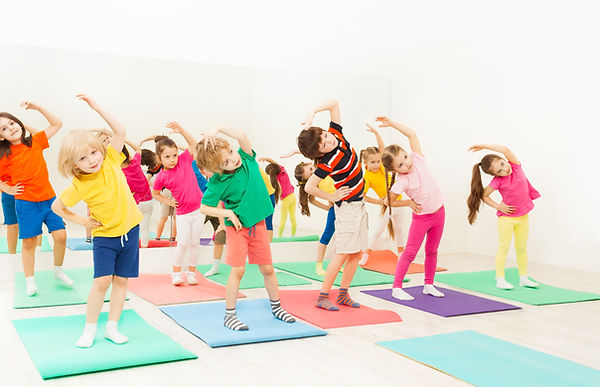 Happy kids doing side bending exercises in gym.jpg