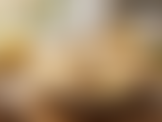 Lemon meringue pie with a slice missing on a wooden table. Lemons, a pie server, and a can of Sweet Cow condensed milk nearby. Sunlit kitchen.