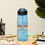 Thumbnail: Clear blue sports bottle with queen bee text back view